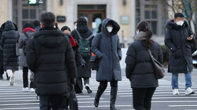 겨울철 추위에 떨며 두꺼운 옷을 입고 있는 사람들의 모습